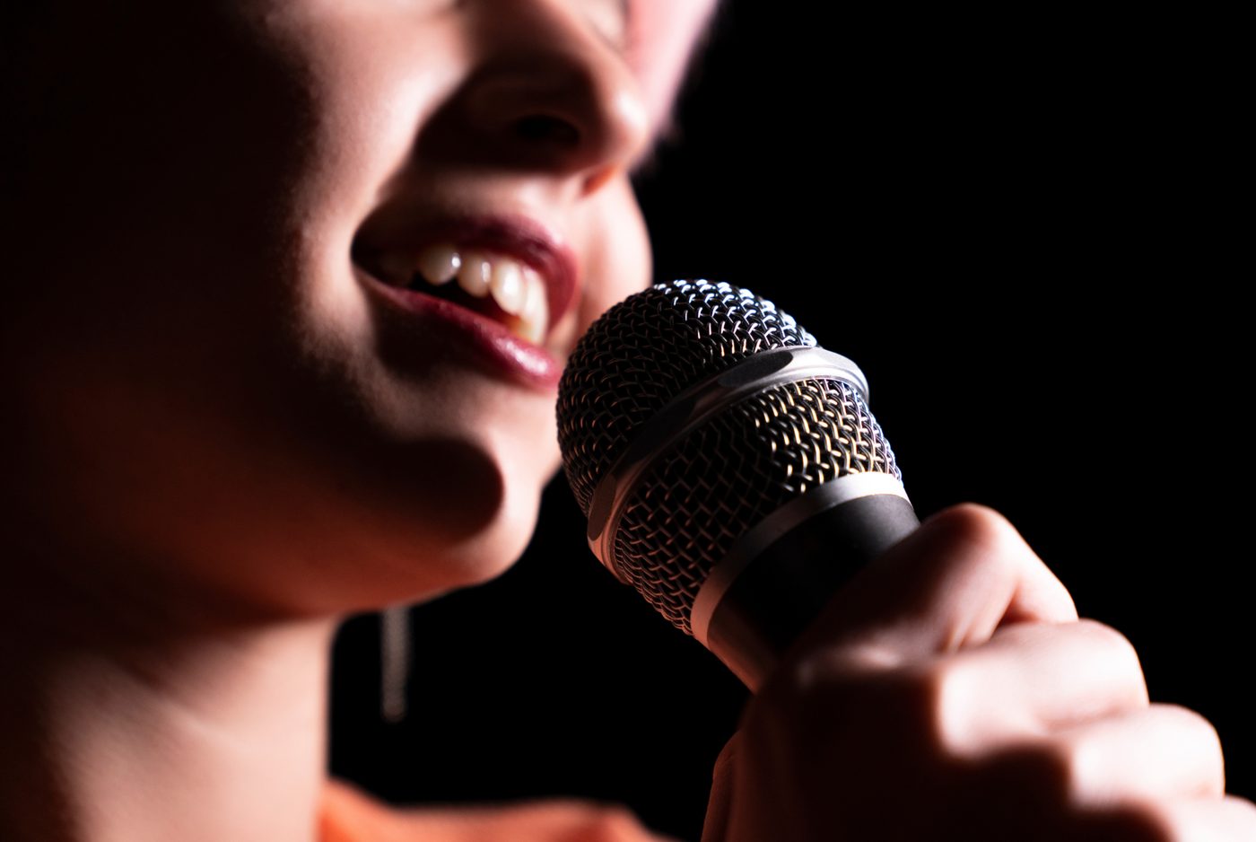 Close-up of a smiling singer at a microphone
